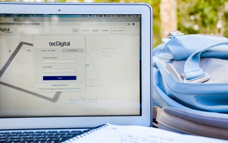 computadora con plataforma TEC Digital y bulto a la par.
