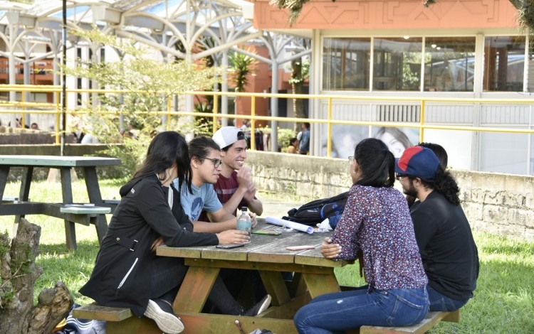 Imagen de varios estudiantes sentados  en una mesita del TEC.