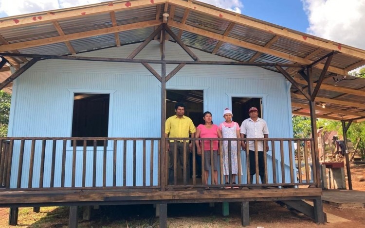 La casa es de madera y de color celeste, en el correpor está la familia beneficiada.