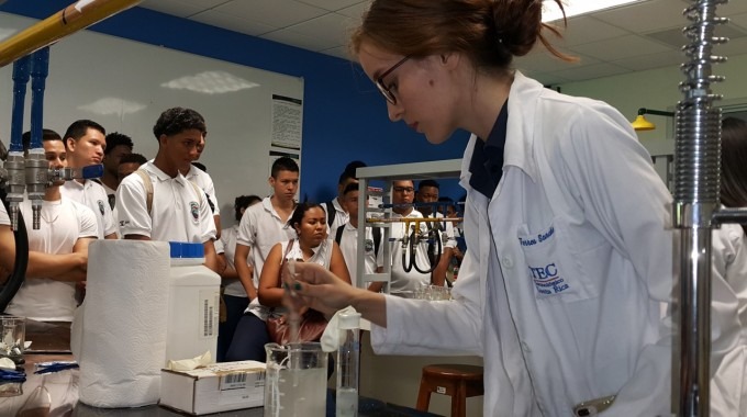 Mujer estudiante en laboratorio de química  realiza experimento 
