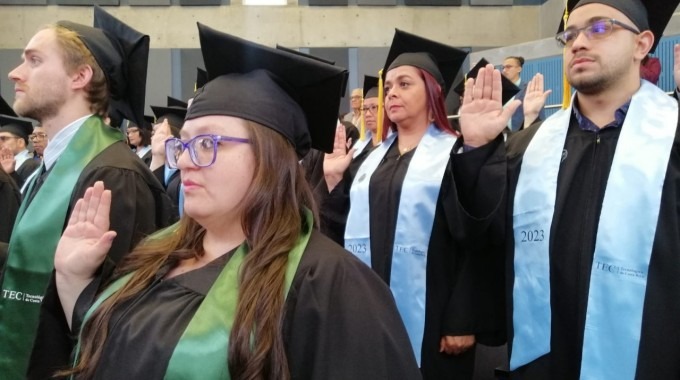 imagen de varios estudiantes levantando la mano en la juramentación.