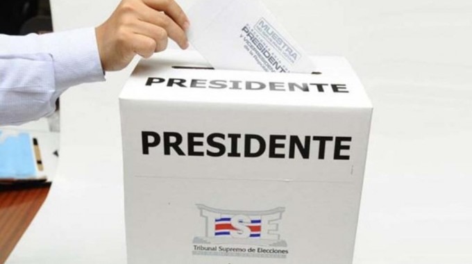 Una mano ingresando un voto en la urna. 