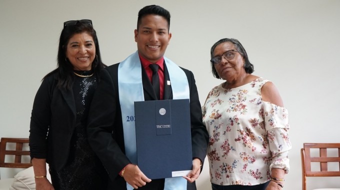 el joven demuestra suu título junto a su familia