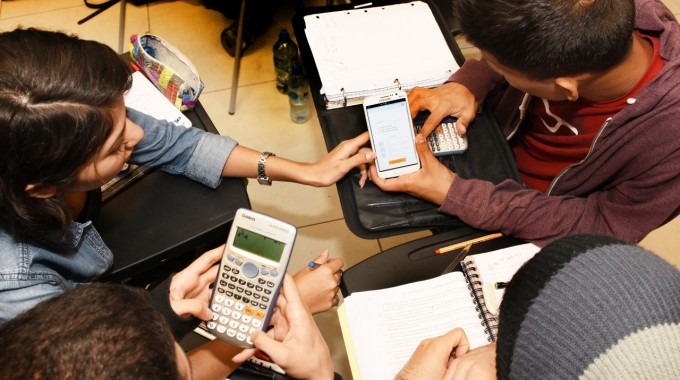 Estudiantes reunidos realizando cálculos matemáticos.