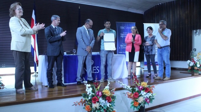 personas en un escenario con certificado de acreditación