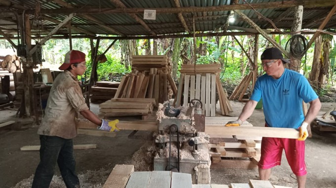 Imagen de dos personas haciendo tarimas de madera balsa