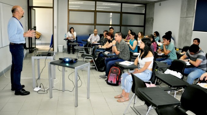 El especialista expone frente a una clase de jóvenes. 