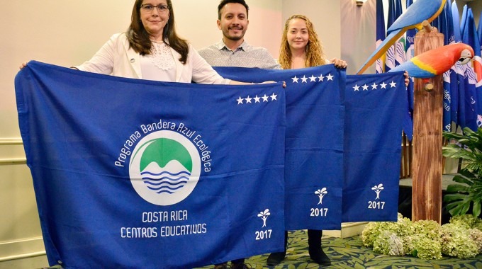 tres personas con banderas azules