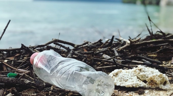 botella plástica y basura frente a playa