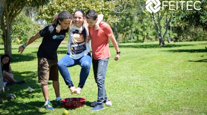 Dos hombres tienen a una mujer cargada, con el objetivo de que no ponga los pies en el suelo, porque están compitiendo y el que equipo que dure más tiempo, es el ganador.