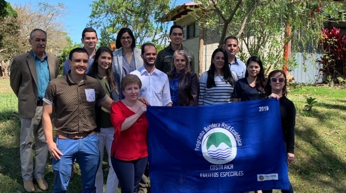 imagen de varias personas posando para la fotografía con la Bandera Azul Ecológica.