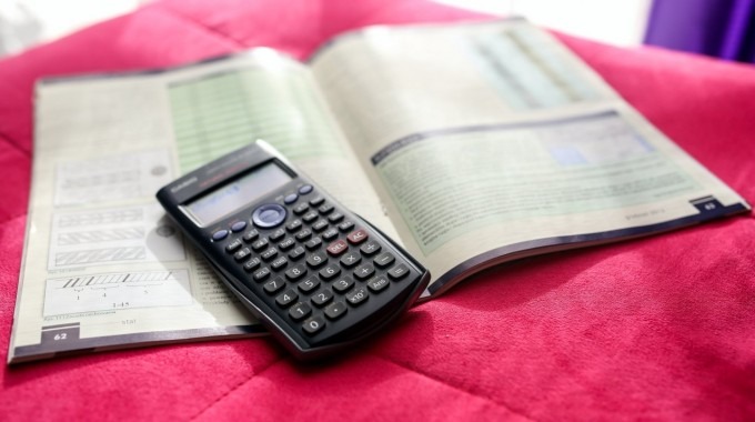 Libro de matemática abierto con una calculadora científica encima. 