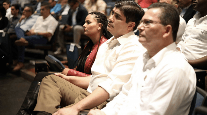 imagen de tres personas observando una exposición