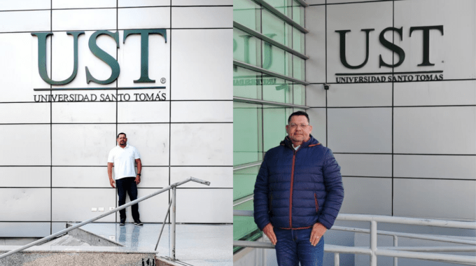 El doctorando posa frente al rótulo de la universidad santo tomás