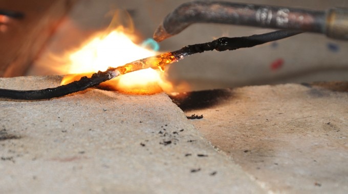 Un cable es sometido al fuego del soplete.