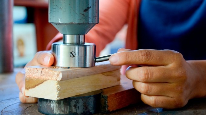 Mano de hombre cortando madera.