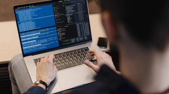 Joven programando código en un computador.