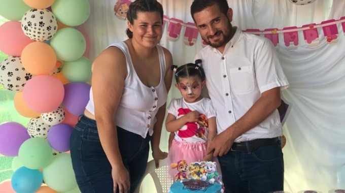 imagen de los papás celebrando el cumpleaños de su hija