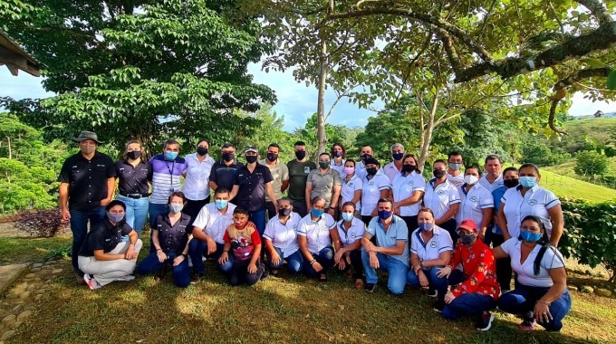 Miembros de la comunidad y de la gira posando en un área verde.