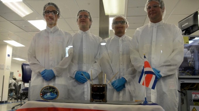 Los cuatro especialistas, tras un vidrio, con el satélite al frente.