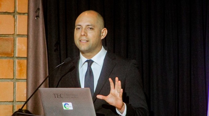 Imagen de una persona frente al podio dando una charla sobre metrología en la sostenibilidad