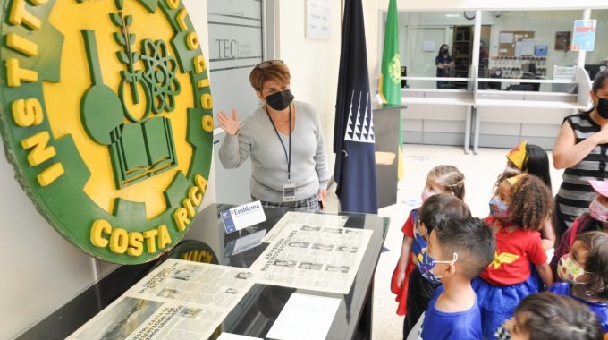 persona enseñando emblema antiguo del TEC a niños