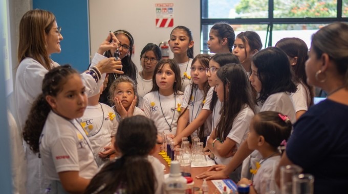 Niñas en el laboratorio de química viendo experimentos.