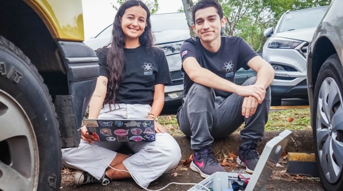 Los jóvenes con la computadora y el dispositivo, realizando pruebas. 
