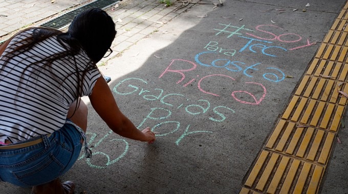 persona escribiendo en piso de pasocubierto del TEC