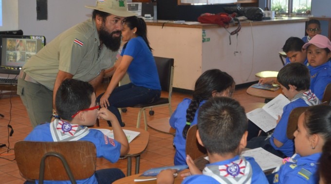 Un guardaparques de la Isla del Coco conversa con un grupo de guías y scouts en un aula del zoológico Simón Bolívar