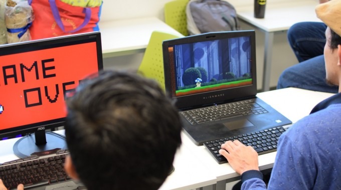 personas jugando videojuegos frente a una computadora 