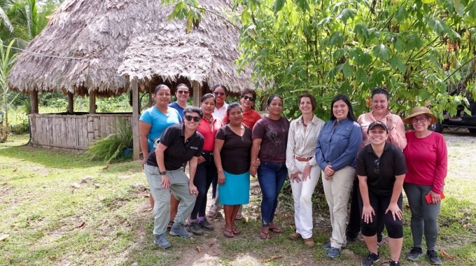 Varias personas posando frente a un rancho indígena