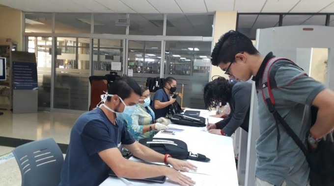 Estudiantes recogiendo computadora prestada.