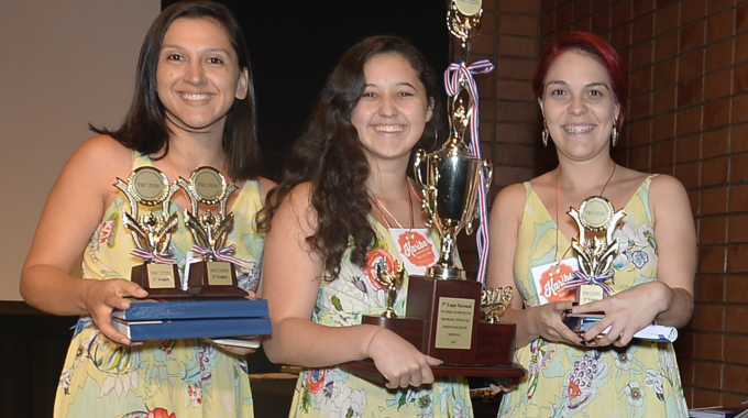 Imagen de tres mujeres con un trofeo