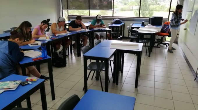 Estudiantes sentados en el aula recibiendo la clase