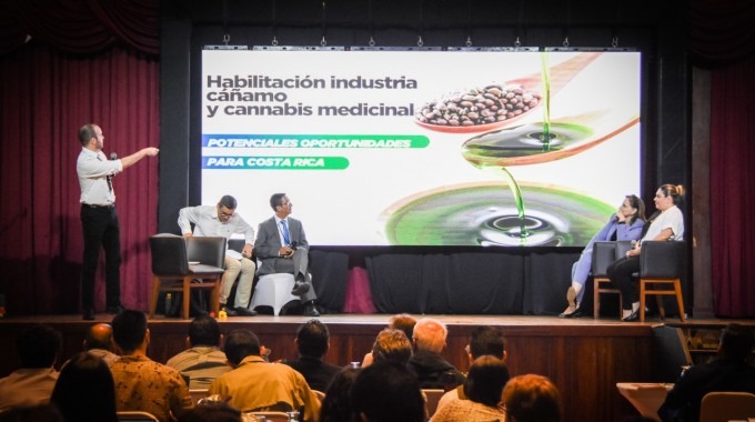 El expositor presenta en el escenario, en el fondo se lee "habilitación del cáñamo y ccannabis medicinal".