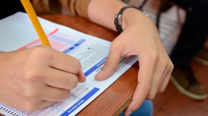 mano de persona con lápiz y examen de admisión