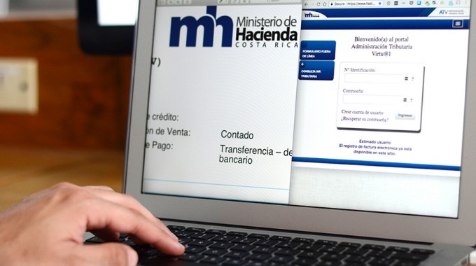 mano de persona en computadora. pantalla muestra sistema del ministerio de hacienda