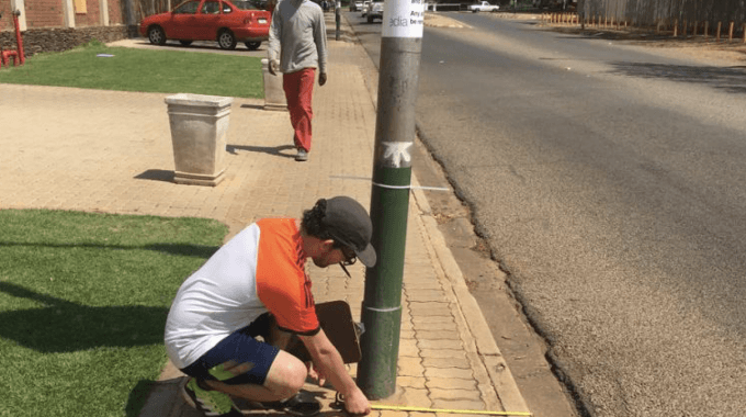 Joven tomando mediciones de obstáculos peatonales en Sudáfrica