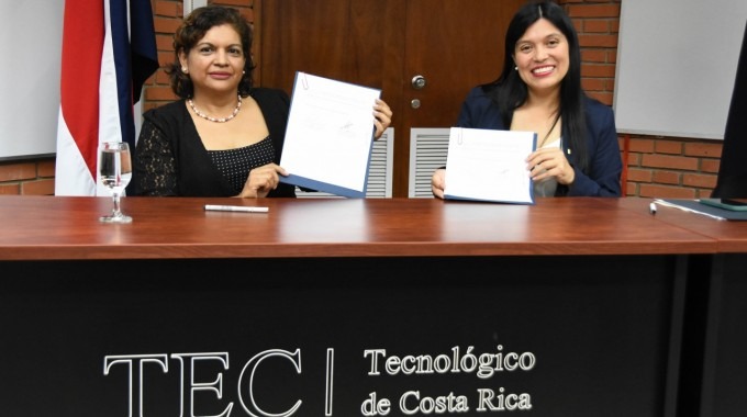 Imagen de dos mujeres mostrando un documento que firmaron.