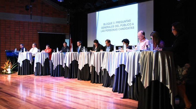 Los diez candidatos en fila, cada uno en una mesa. 