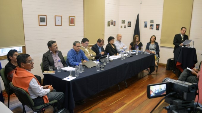 Se muestra la sala de la Casa Cultural, con los candidatos sentados en una mesa larga.