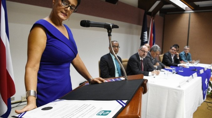 mujer leyendo certificado de acreditación en conare