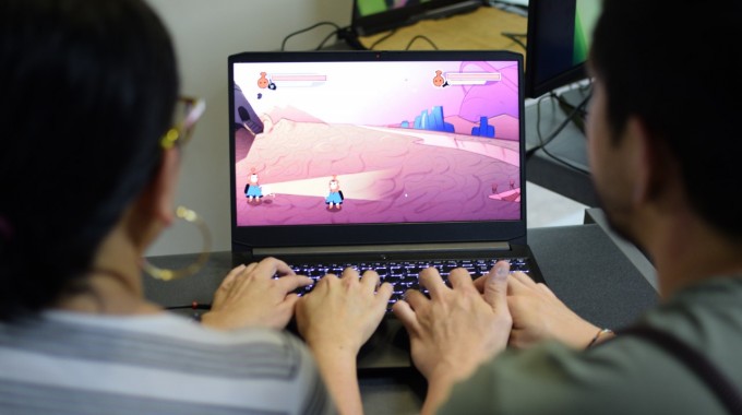 dos jóvenes frente a computadora con videojuegos