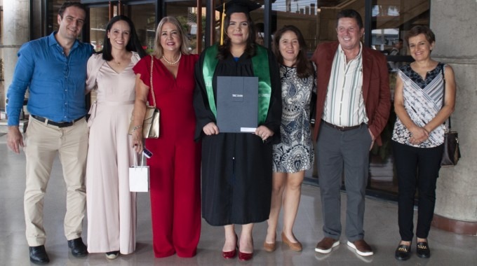 Imagen de la estudiante graduada junto a sus familiares