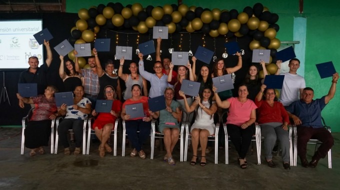 las personas graduadas muestran su título.