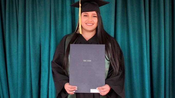 Imagen de una estudiante con el título universitario.