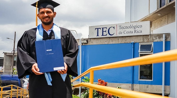 Fotografía del graduado sosteniendo el título. 