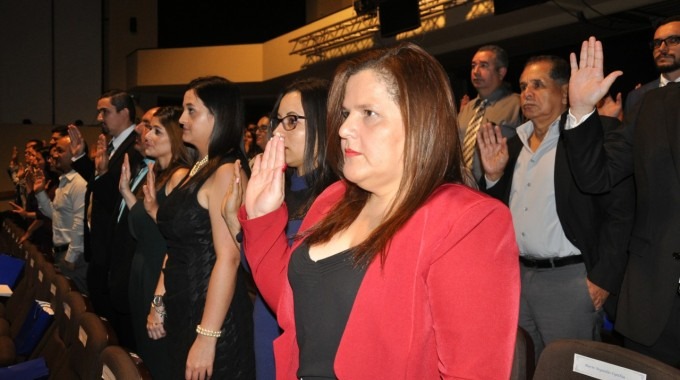 Imagen de varias personas levantando la mano derecha durante la juramentación.