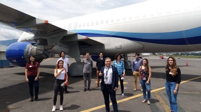 Grupo de estudiantes posando frente a un avión.